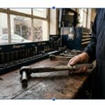 A professional mechanic showing how to set a torque wrench correctly on a garage workbench