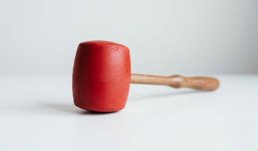 Rubber mallet, showcasing the dense matte rubber head contrasted with its smooth wooden handle.