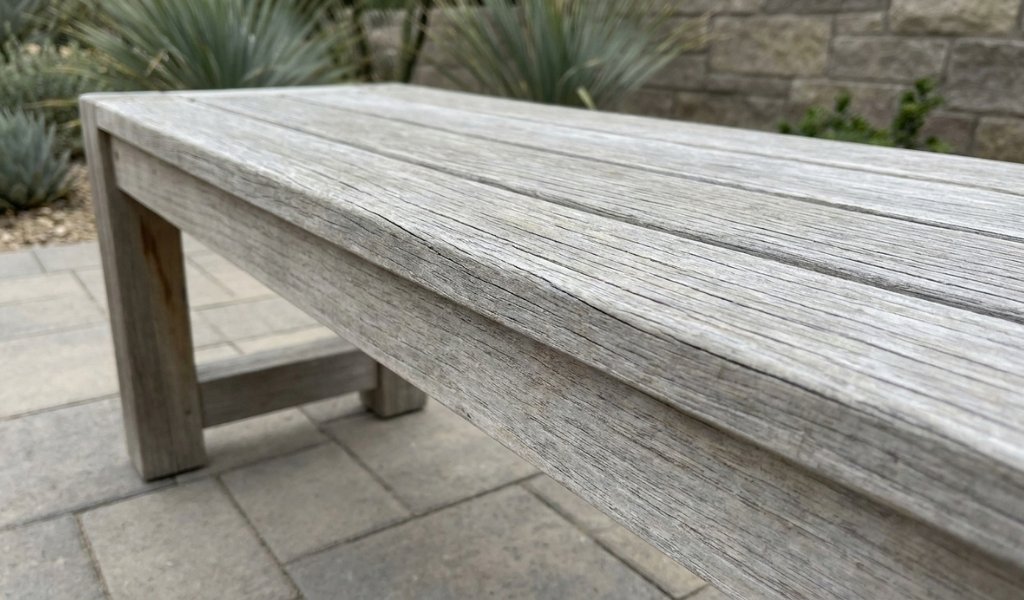 Aged teak outdoor furniture showing natural silver gray patina after weather exposure